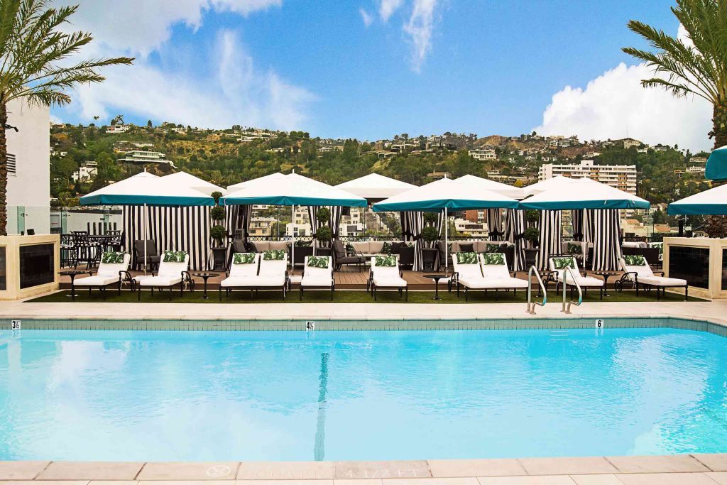 A pool and sun loungers with sprawling views of the Hollywood Hills.