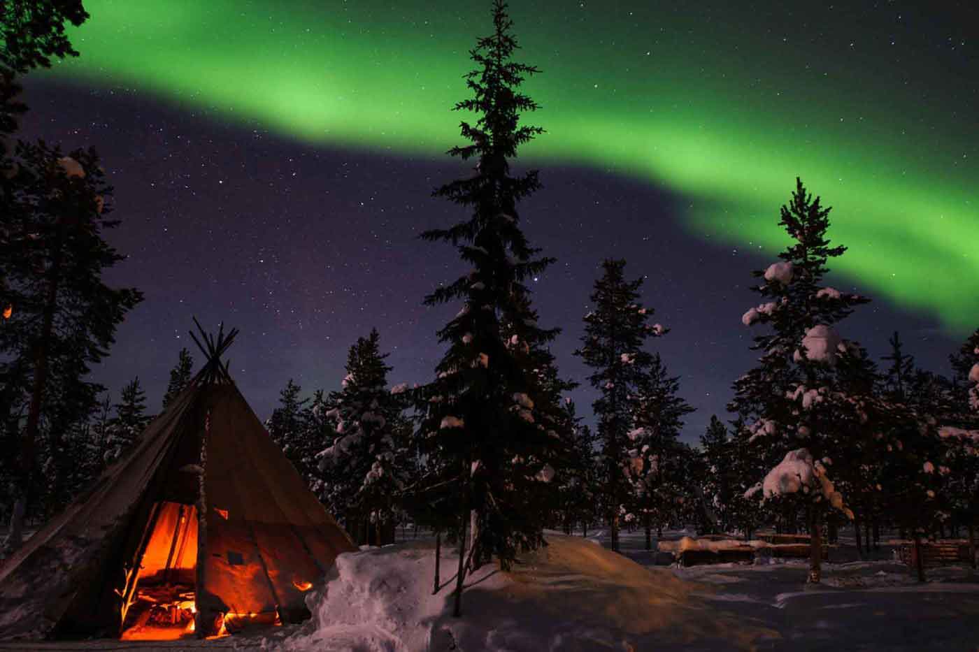 Northern Lights above tents at the reindeer lodge in Jukkasjärvi, Sweden