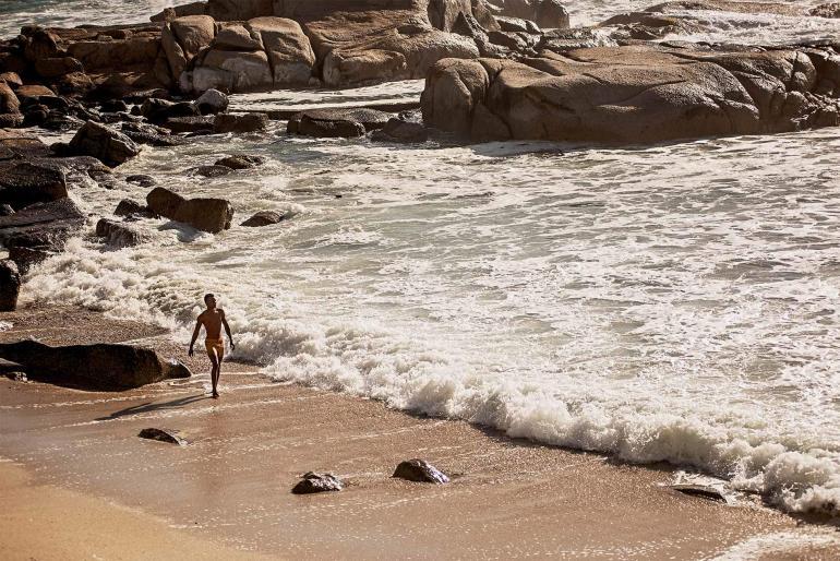 Model wearing 'Setter Nerano Sunflower/Espresso Shorter Length Swim Short' by Orlebar Brown in Bantry Bay, Cape Town, South Africa