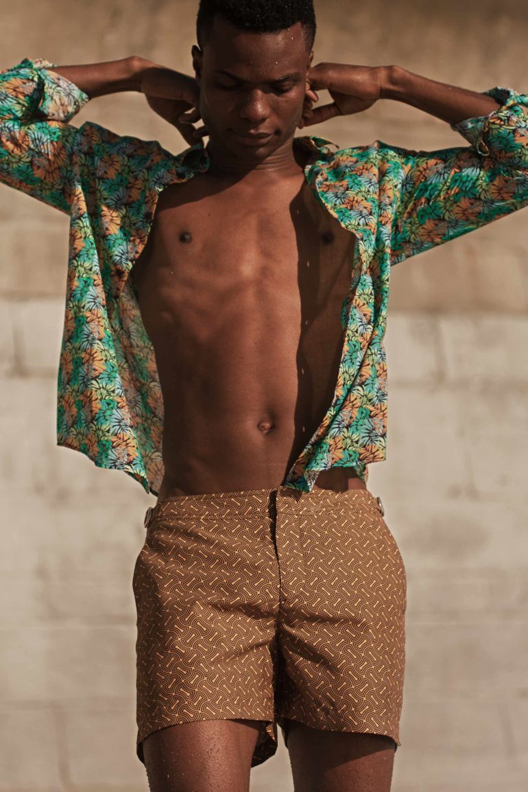 Model wearing cotton print shirt by Vilebrequin and 'Setter Nerano Sunflower/Espresso Shorter Length Swim Short' by Orlebar Brown in Bantry Bay, Cape Town, South Africa