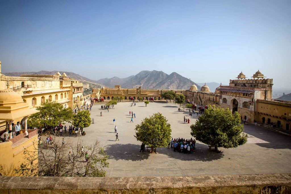 Tourists explore a fort in a mountainous region of India