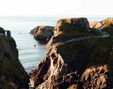 A hiker explores the Carrick-a-Rede Rope Bridge, Northern Ireland