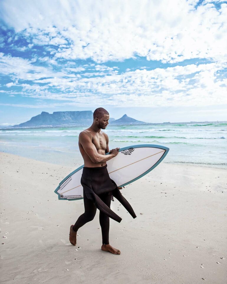 Model goes surfing on beach in Cape Town, South Africa