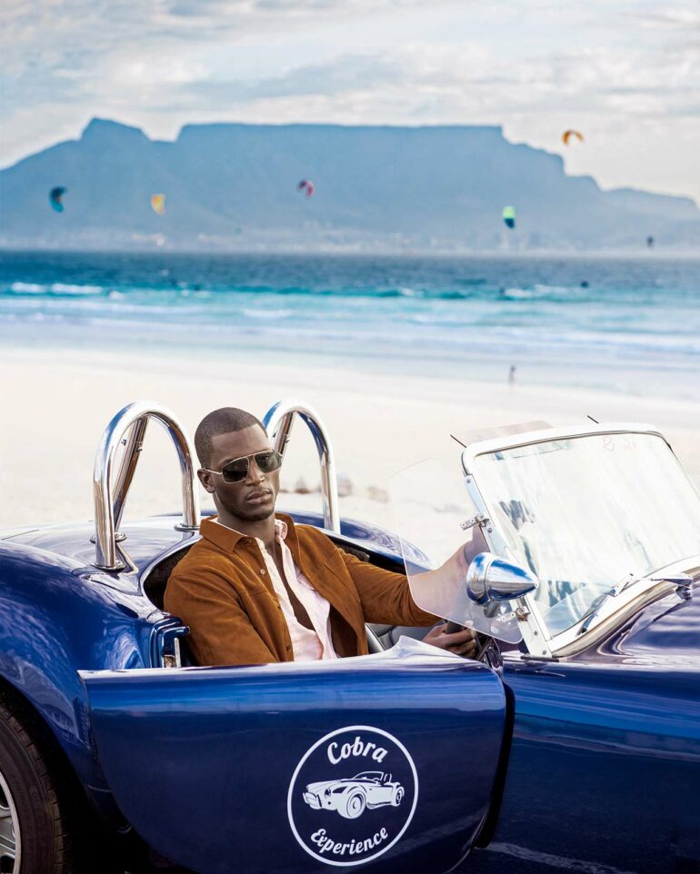 Model poses in Cobra sportscar, South Africa
