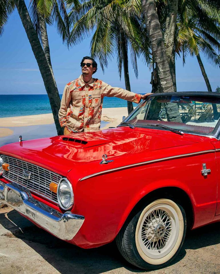 Model poses with red car on the beach, Phuket, Thailand