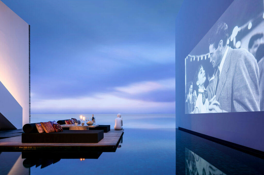 An outdoor cinema beside an infinity pool.