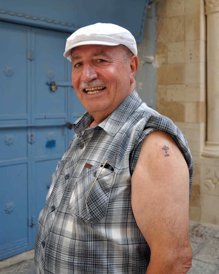 A man shows off his tattoo from Razzouk's Tattoo Parlour, Jerusalem, Israel