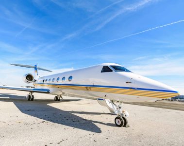 A Gulfstream G550 is parked near a landing strip