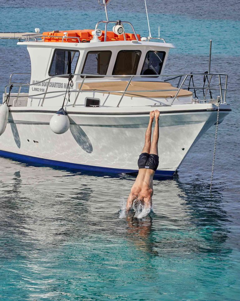 Malta jumps off a boat into the sea off Comino, Malta