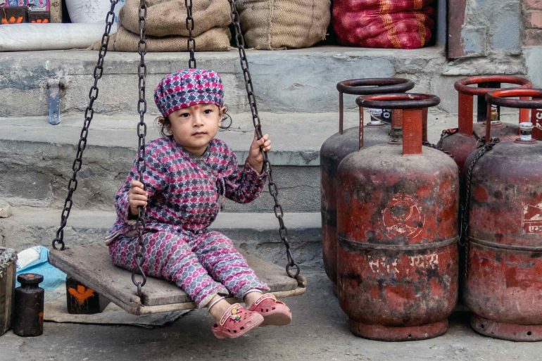 A girl rocks back and forth on a scale in Kathmandu, Nepal
