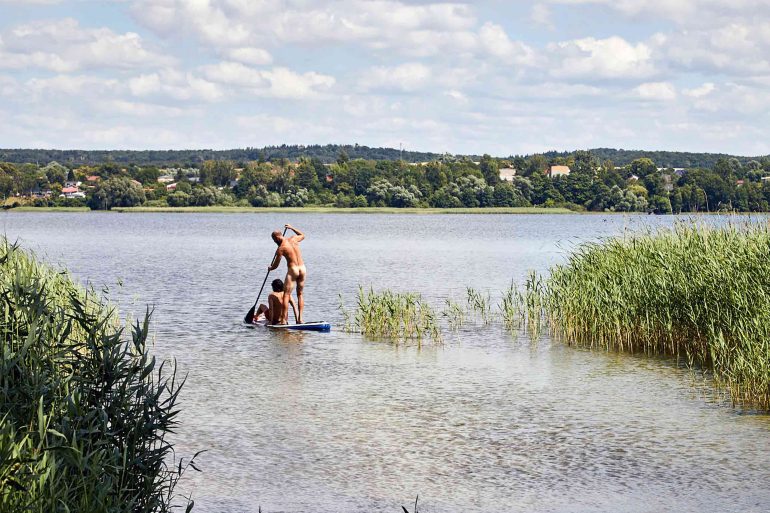 Gary Abela and Andreas Zaremba paddle-boarding near Hof Flieht, Uckermark, Germany