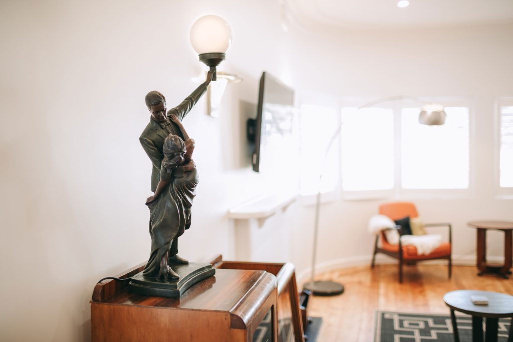 An art deco style orb lamp with a brightly lit room in the background