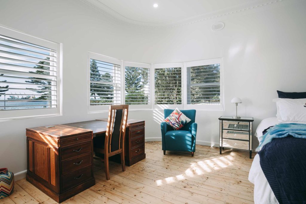 A stylish, naturalistic bedroom with plenty of natural light at Deco Beach Luxury Apartments, Port Lincoln, Australia