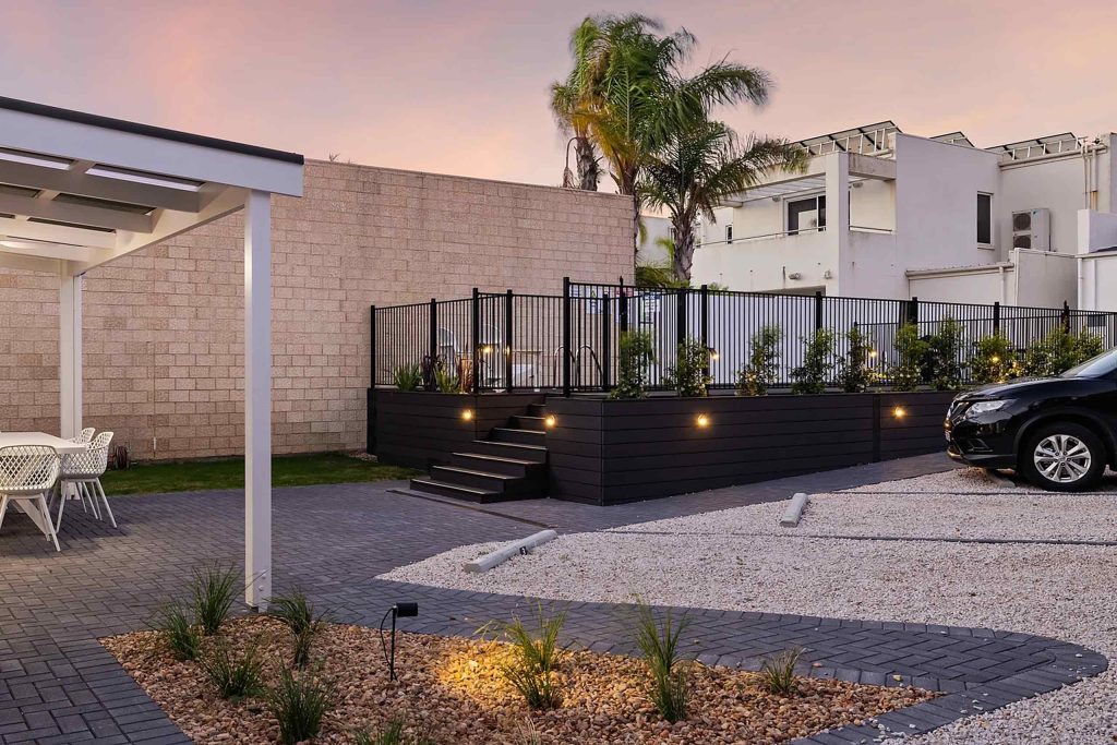 An outdoor pool surrounded by a black deck at Deco Beach Luxury Apartments, Port Lincoln, Australia
