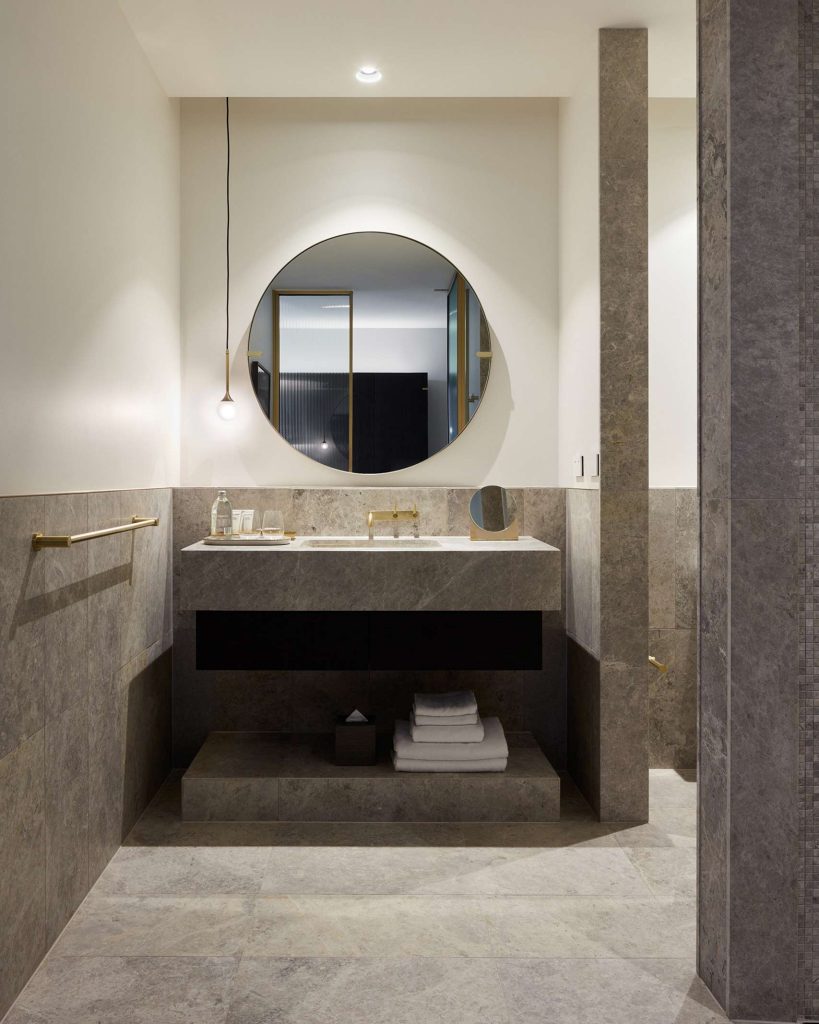 Luxury marble bathroom with circular mirror