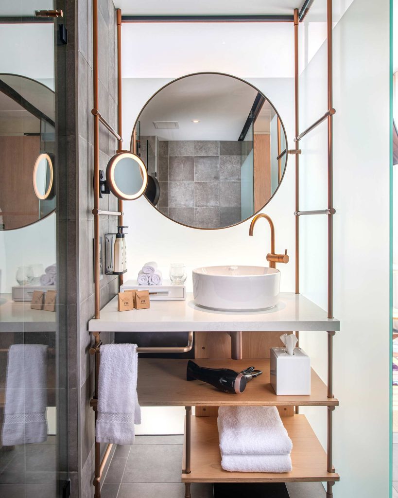 Sophisticated hotel suite. bathroom with a circular mirror.