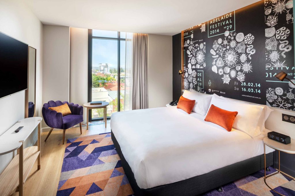 Bedroom suite with lively carpet and wall art at Hotel Indigo Adelaide Markets, Adelaide, South Australia.