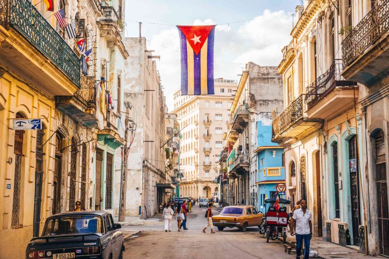 The Cuban flag hangs above a street in Cuba