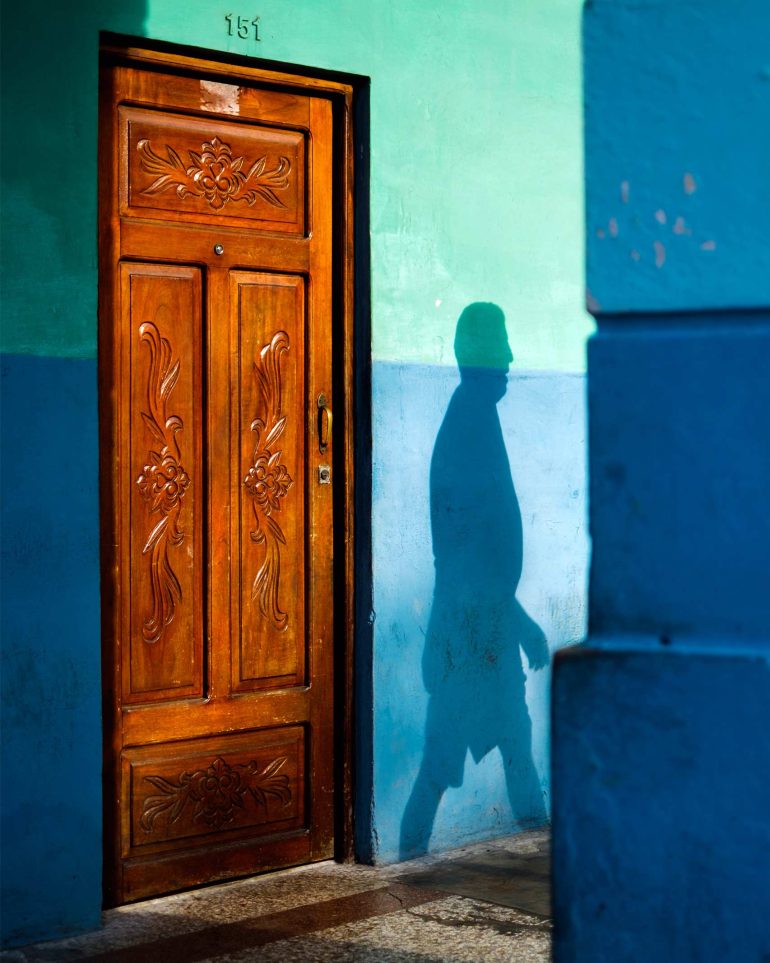 Shadow of a man thrown onto colourful walls in Havana, Cuba