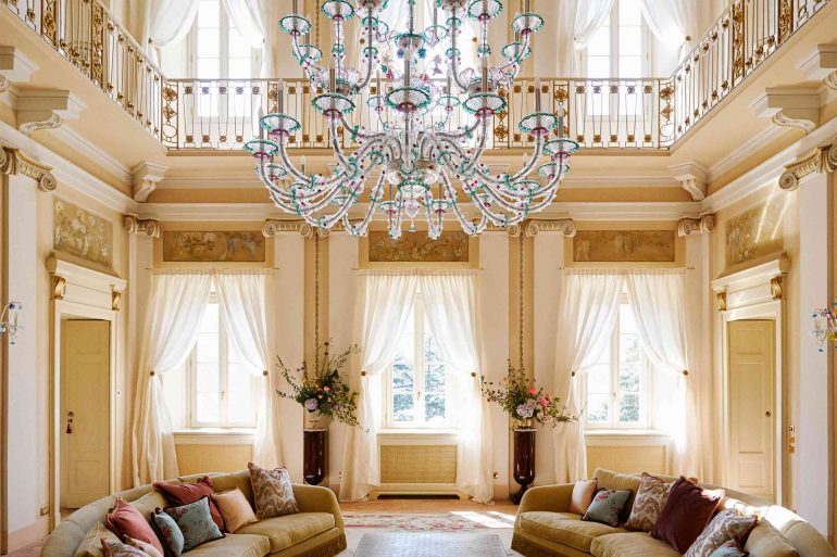 A chandelier hangs above sofas at Passalacqua, Lake Como, Italy