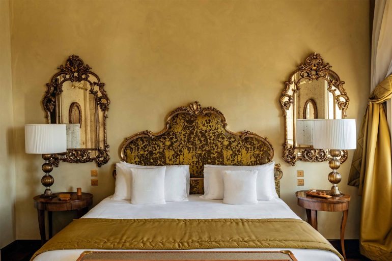 Bed in a golden room at Passalacqua, Lake Como, Italy