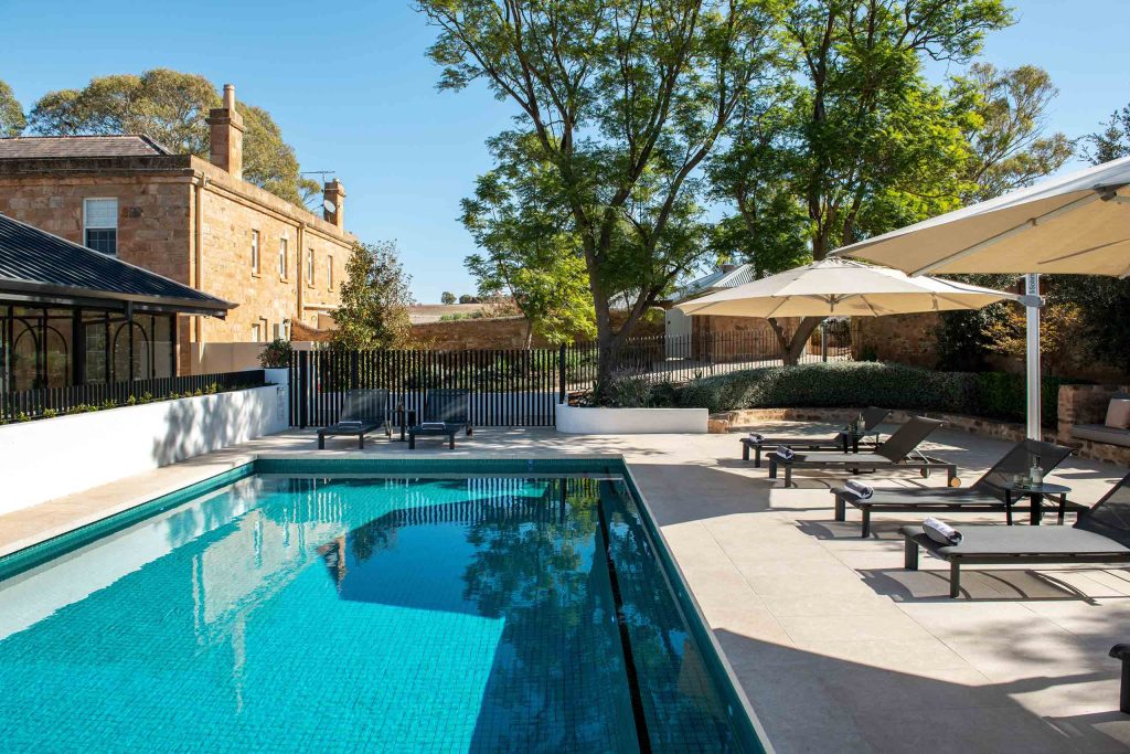 A brilliant blue outdoor pool with sun loungers