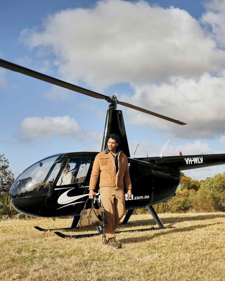 Model Nathan McGuire walks in front of a helicopter, South Australia menswear editorial, Australia