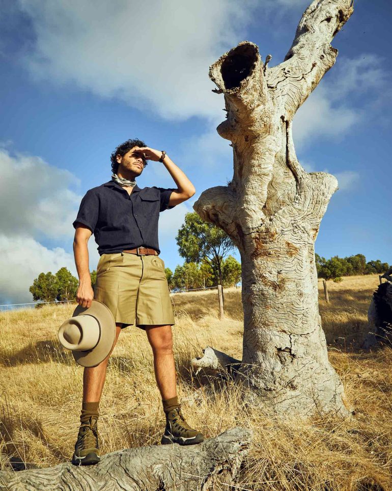 Model Nathan McGuire stands in front of a tree trunk, South Australia menswear editorial, Australia