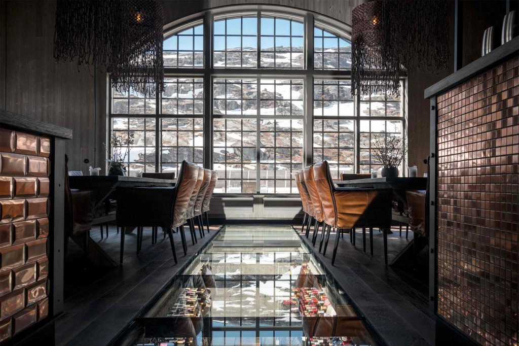 A large window reveals the mountainous landscape near Niehku Mountain Villa, Riksgränsen, Sweden