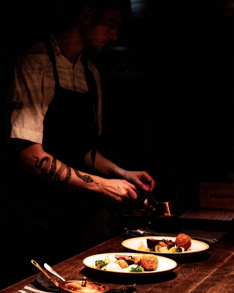A staff member dresses a meal before it is served at Niehku Mountain Villa, Riksgränsen, Sweden