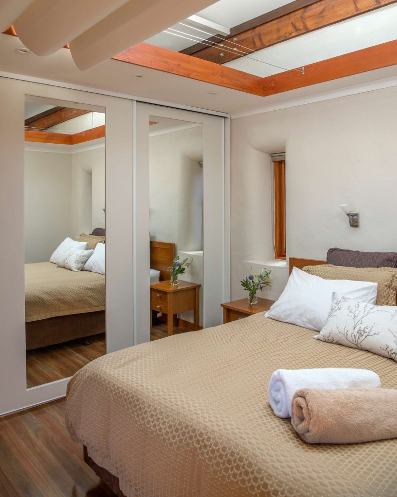 A cosy bed with a mirrored wardrobe at Rawnsley Park Station, Flinders Ranges, Australia