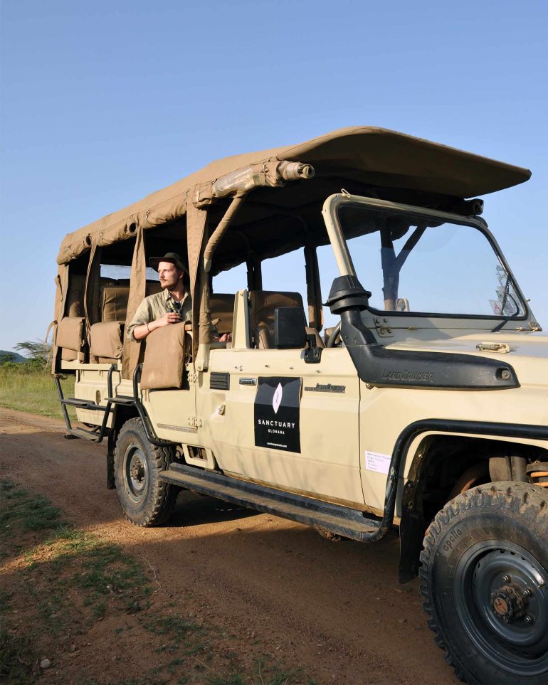 Steffen Michels looks out over the landscape from a safari vehicle part of Sanctuary Retreats, Masai Mara, Kenya