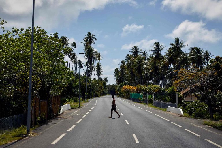 A man crosses a road in The Islands of Tahiti, French Polynesia