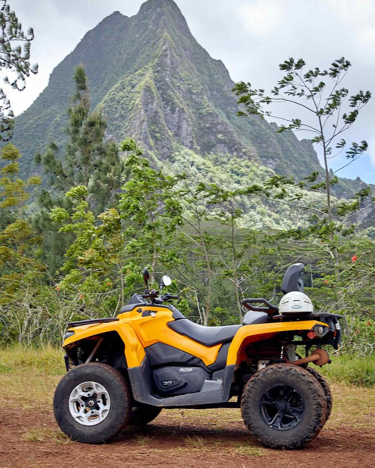 A quad bike is parked in front of the dramatic scenery of The Islands of Tahiti, French Polynesia