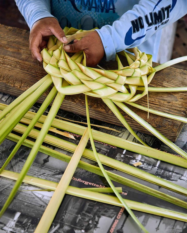 Locals weave palm leaves in The Islands of Tahiti, French Polynesia