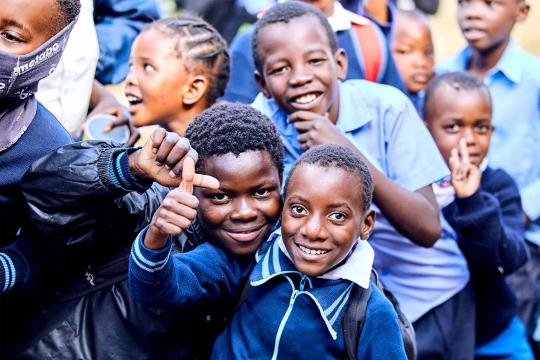 Local school children pose for a picture near the Shambala Private Game Reserve, South Africa