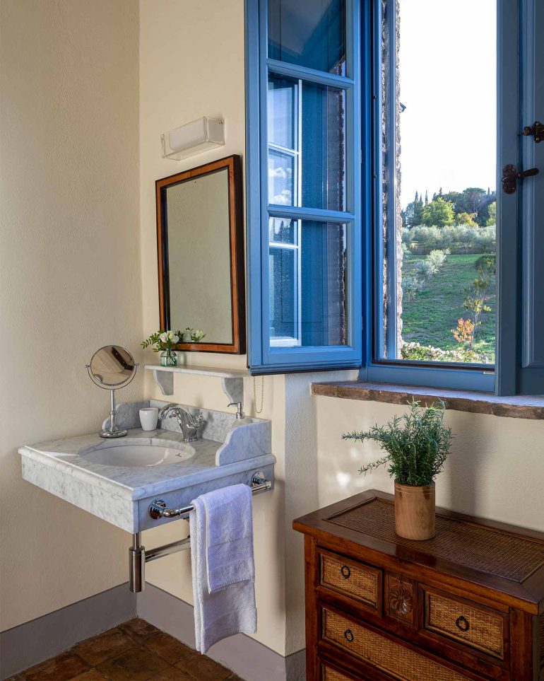 Bathroom featuring a sky-blue window frame at the Borgo Pignano, Tuscany, Italy