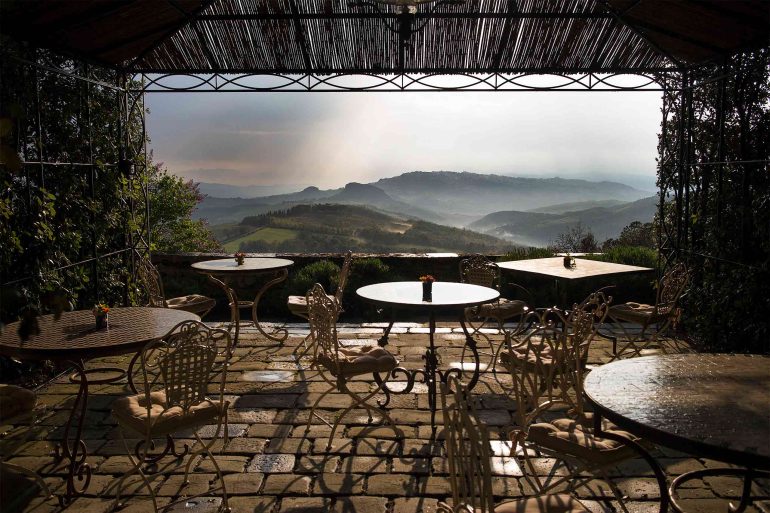 An outdoor seating area with views over the Tuscan countryside, Italy