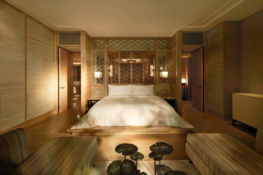 A warm, golden-hued bedroom at Capella Bangkok, Thailand