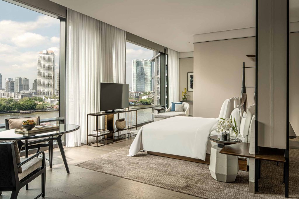 A stylish, neutral-coloured bedroom with panoramic views of the Chai Phraya River