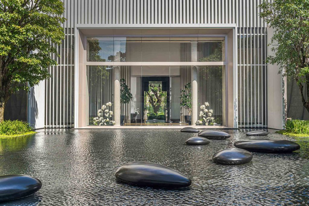 Contemporary art in the form of large pebbles protrude from a water feature at the Four Seasons Bangkok at Chao Phraya River, Bangkok, Thailand