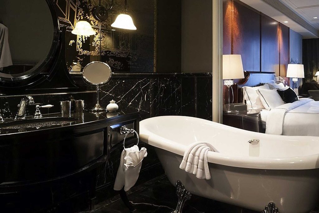 A 1920's inspired bathroom with a freestanding bathtub and monochromatic colour scheme at Hotel Muse Bangkok Langsuan – MGallery Collection  