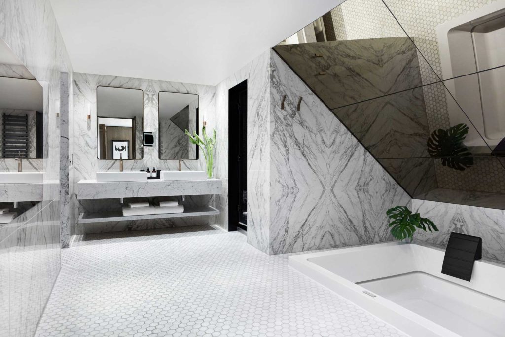 An immaculate, marble and tile bathroom with a grey and white colour scheme.