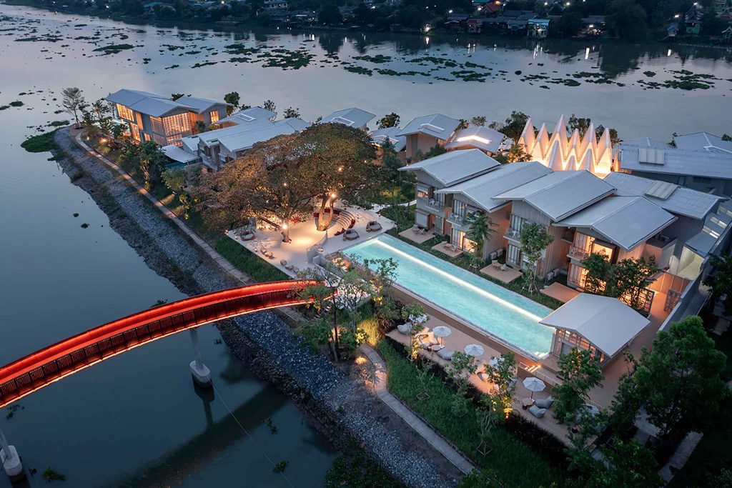 Birds-eye external shot of the Sala Bang Pa-In Hotel at twilight with its distinct red bridge in view