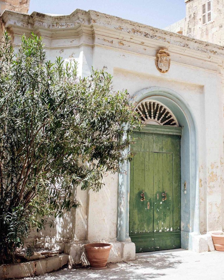 A green door contrasts beautifully with the white walls of a building in Mdina, Malta