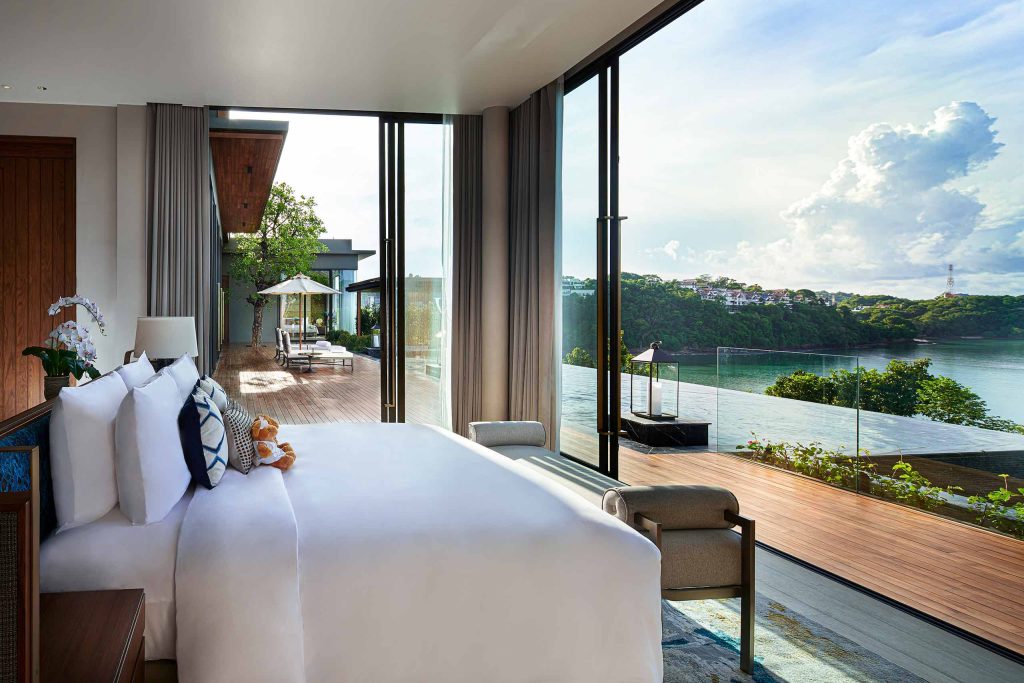 A bedroom with floor-to-ceiling panoramic views of the Andaman Sea