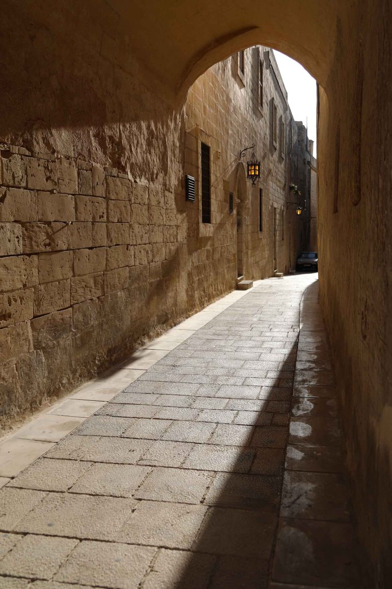 A narrow passageway lit up by the sunset in Mdina, Malta
