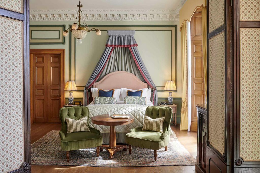 Bedroom with two green armchairs at the Gleneagles Townhouse, Edinburgh. Stay during the The Edinburgh Festival Fringe.