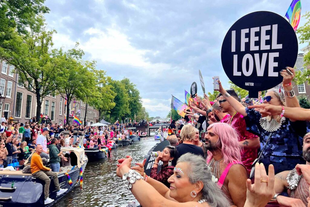 People gather around one of the city's canals during Amsterdam Pride, Amsterdam, The Netherlands