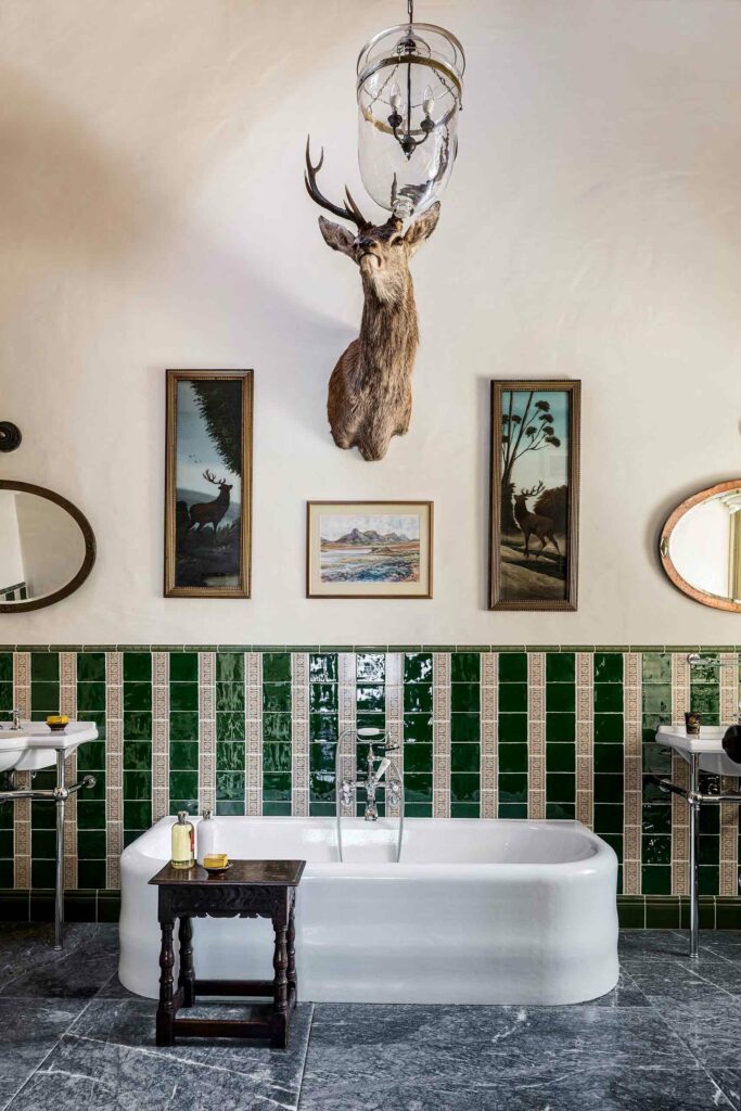 A bathroom with taxidermy and green tiles at Ardfin, Inner Hebrides, Scotland.